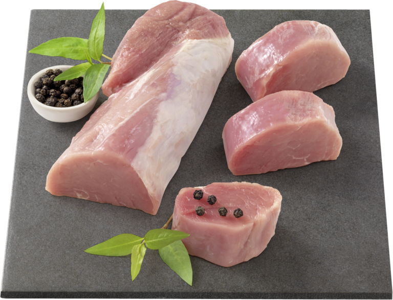 Das Bild zeigt ein rohes Schweinefilet, auf einem schwarzen Schneidebrett angerichtet. Das Fleisch ist in einem Stück und in Scheiben geschnitten, die Scheiben sind mit schwarzen Pfefferkörnern garniert. Außerdem sind einige grüne Blätter als Dekoration zu sehen.