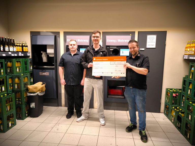 Zu sehen ist eine Fotografie von der Spendenübergabe im EDEKA Kissel SBK Kandel an das Jugendzentrum Kandel. Auf dem Bild zu sehen ein Mitarbeiter des Marktes und zwei Mitarbeiter der Jugendzentrums. Zwei der Männer halten zusammen einen Sparkassen Check in Höhe von 700€ Richtung Kamera.